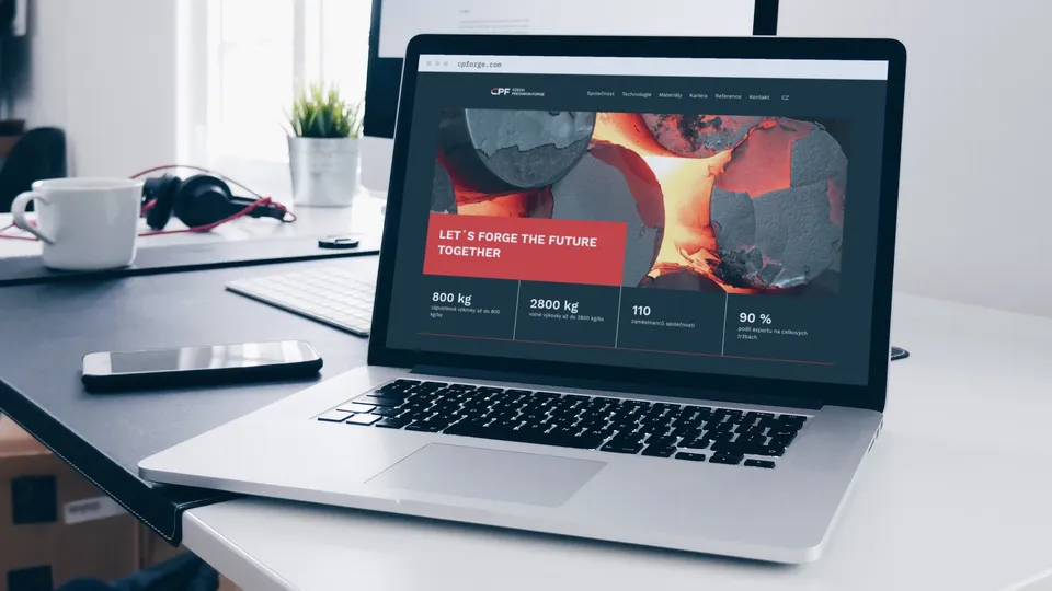 Startseite von Czech Precision Forge mit dem Foto eines glühenden Schmiedeteils auf einem Laptop